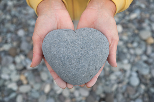 manos sosteniendo el corazón / piedra en forma de corazón photo