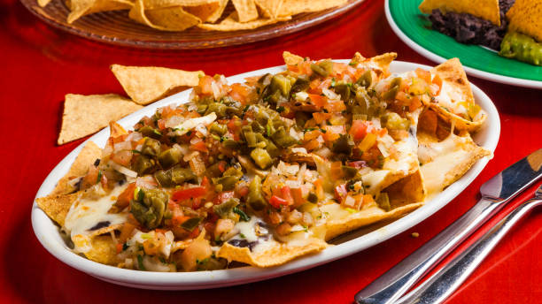 istock Mexican food: nachos with melted cheese, tomato and peppers. 645802814