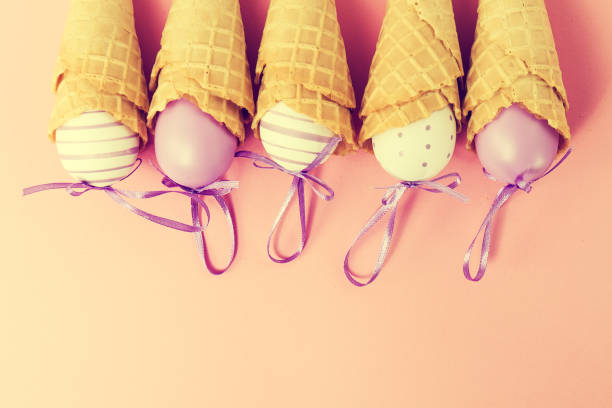 istock Colorful Ice Cream Cones with Easter Eggs on Pink Background 645818594