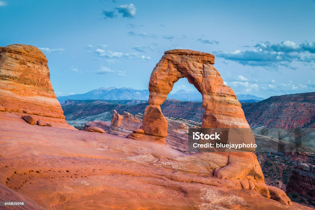 Classic view of famous Delicate Arch at sunset, Utah, USA Classic postcard view of famous Delicate Arch, symbol of Utah and a popular scenic tourist attraction, in beautiful post sunset twilight at dusk in summer, Arches National Park, Moab, Utah, USA American Culture Stock Photo