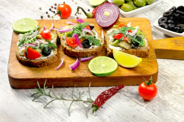 Sandwich with fish-herring and salad on wooden table