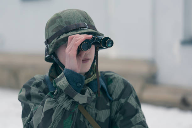 istock Soldier looking at target through binoculars at firing field 645833888