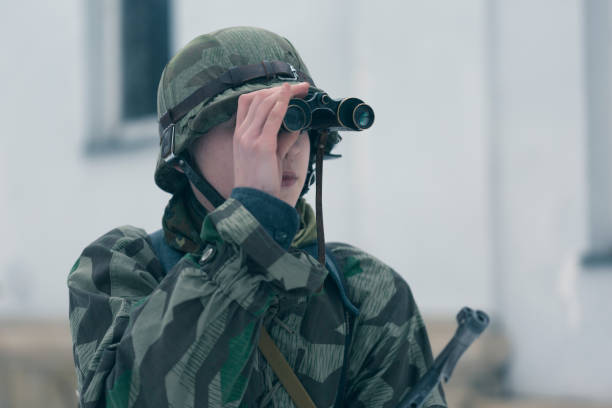 istock Soldier looking at target through binoculars at firing field 645833902