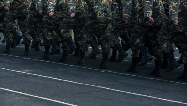 soldats marchant sur terrain - camouflage pants photos et images de collection
