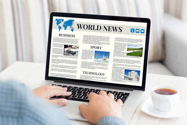 istock man holding notebook with world news site on the screen 645838750