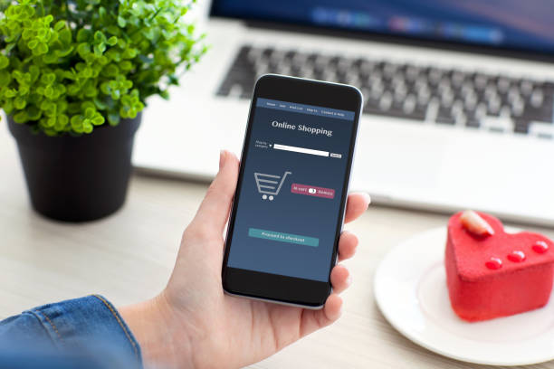 istock female hands holding phone with app online shopping and notebook 645841230