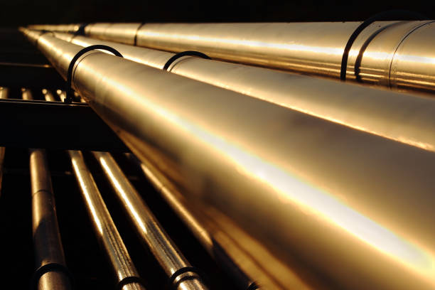 golden steel pipes in oil refinery during sunset stock photo