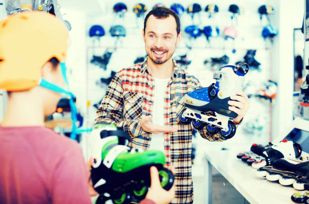 istock Seller assisting boy in choosing roller-skates 645844992