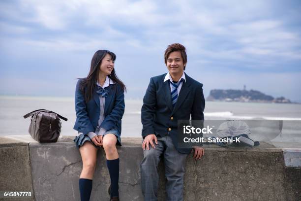 High School Student Couple Being Relaxed At Beach Stock Photo - Download Image Now - High School Student, Japanese Ethnicity, Uniform
