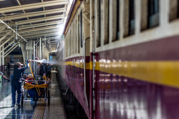 철도 트랙에 철도 기차는 방콕 역에 노동자에 의해 청소를 위한 세척 얻을. 그것이 저렴 하기 때문에 인기 있는 여행 기차로 사람들. - tamping 뉴스 사진 이미지