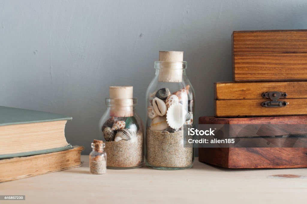 memorabilia souvenirs like a bottles with seashells, books and wooden boxes from different countries Bottle Stock Photo