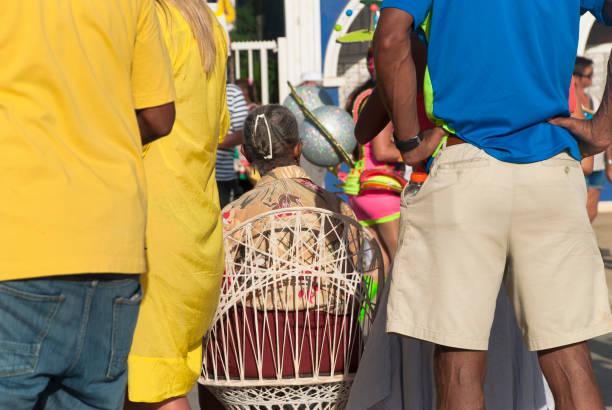 Two excited young women concentrating on a duck fishing game at a funfair, trying to win a prize