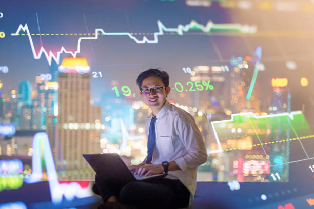 istock Young business man using laptop and digital tablet cityscape background 645864230