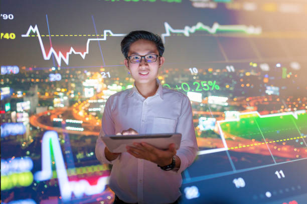 istock Young business man using laptop and digital tablet cityscape background 645864452