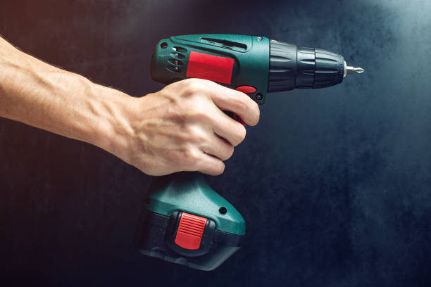 istock male hand holding a screwdriver, for screwing screws 645886272