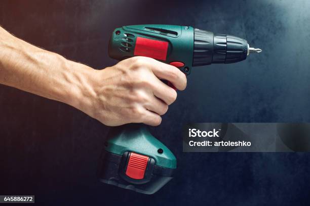 Male Hand Holding A Screwdriver For Screwing Screws Stock Photo - Download Image Now