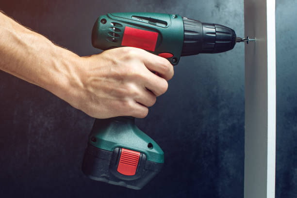 istock male hand holding a screwdriver, for screwing screws 645886294