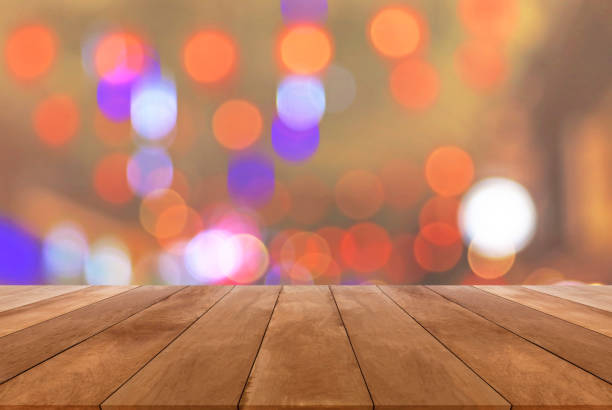 istock Abstract blurred image and bokeh lights in the night with wood table 645896678