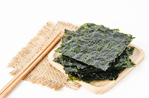 Japanese food nori dry seaweed sheets with salt and chopsticks on white background.