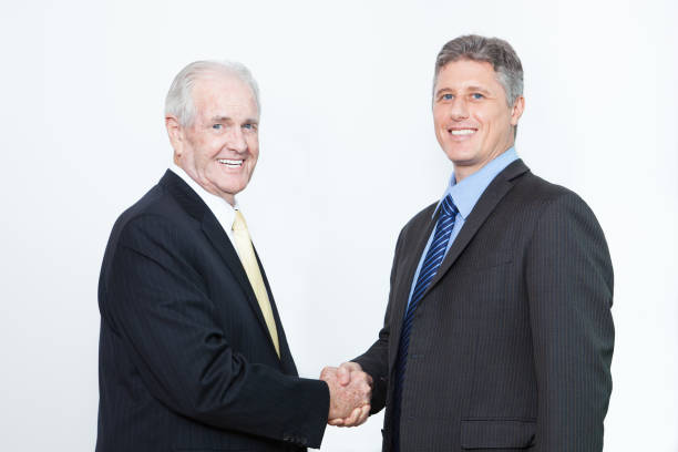 istock Smiling business partners concluding successful deal and making handshake, Successful businessmen looking at camera and congratulating each other. Partnership concept 645900502