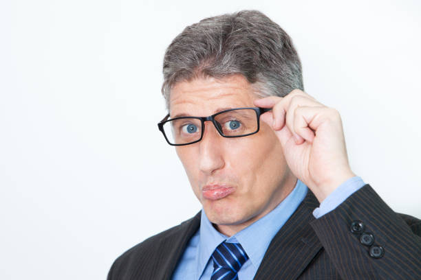 istock Upset middle-aged businessman grimacing face and looking at camera. Confused manager adjusting eyeglasses. He received bad news. Gray-haired man pursing lips. Irony concept 645900526
