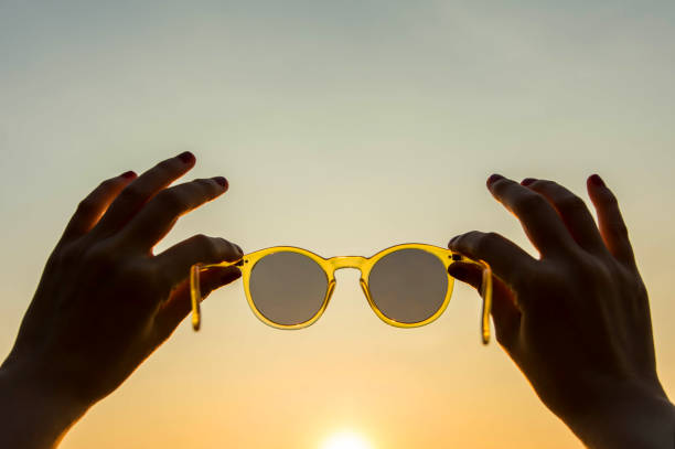 istock Hand raised up sunglasses in summer sky 645912336