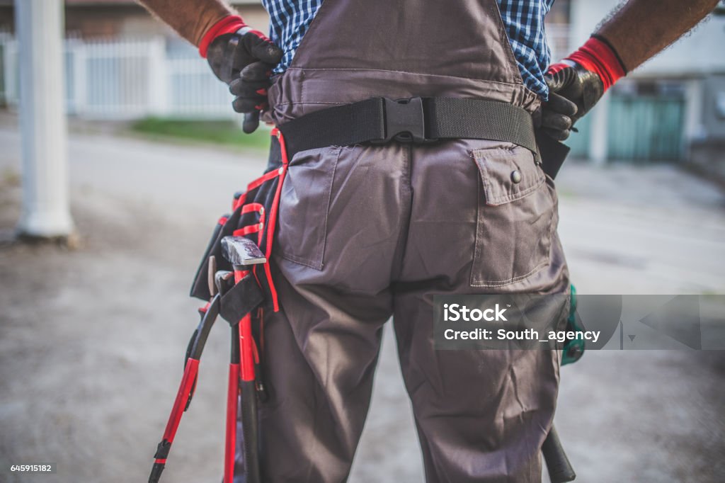 Equipped manual worker One man, cropped photo, tool belt, rear view. Belt Stock Photo