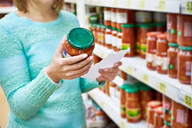 istock Woman chooses lecho tomato at grocery store 645920276