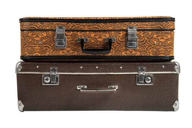 Old suitcase with brown hat in the station on the platform. Concept of waiting a train, taxi, bus or other transport. Historical atmosphere. Vintage style. Retro things. Traveling or emigration.