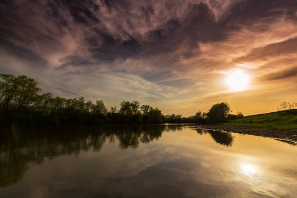 istock Sunset sky over natural lake, with dark red and grey cumulus clouds 645936276