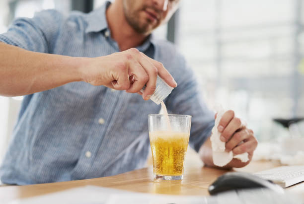 I hope this will dissolve away my pain too Cropped shot of an unrecognisable businessman dissolving a sachet of medicine in a glass of water in an office sachet stock pictures, royalty-free photos & images