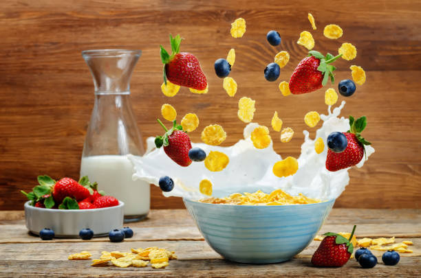 istock Healthy breakfast with milk, flying corn flakes, strawberries and blueberries 645948904