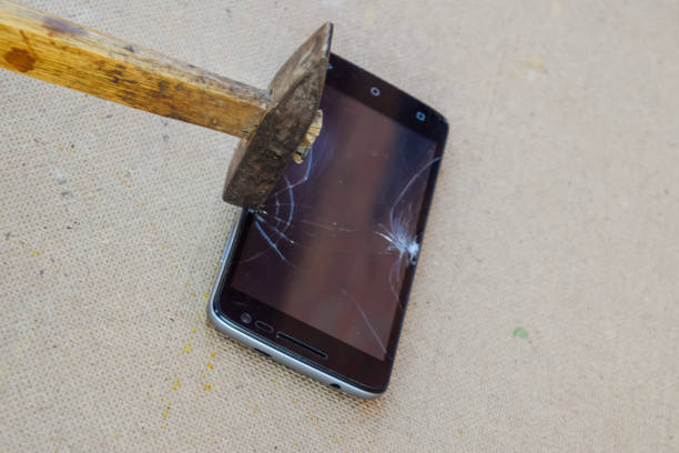 istock Hammer and smartphone. The screen of the smartphone, a broken ha 645949694