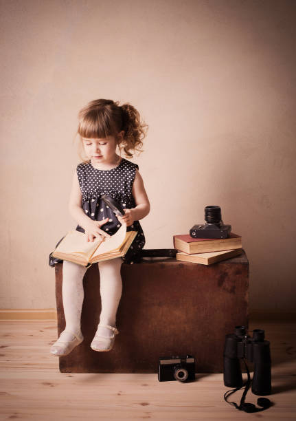 istock little girl reading a book on the old suitcase 645964228