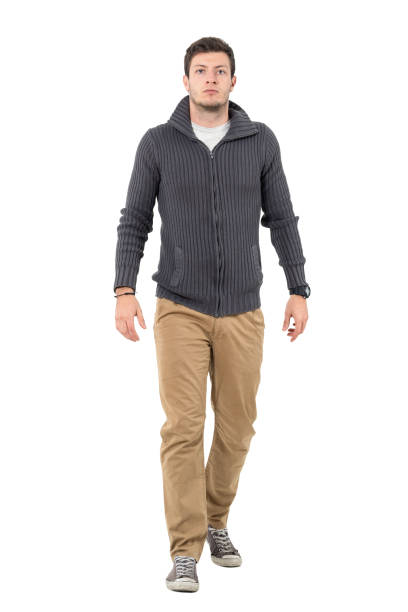istock Serious man wearing jumper and beige pants walking at camera 645964560