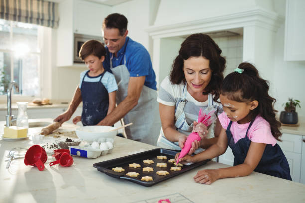 istock Happy family preparing cookies in kitchen 645971182