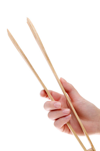 istock hand holding wooden kitchen tongs 645980932