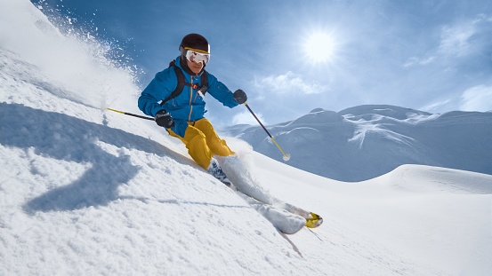 Skier skiing on mountain slope.