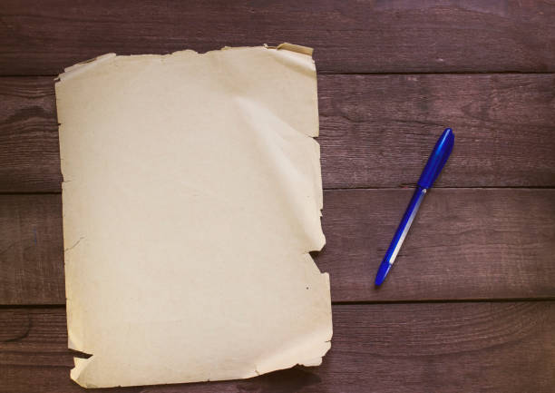 istock Old blank white paper with pen on wooden background 645985836