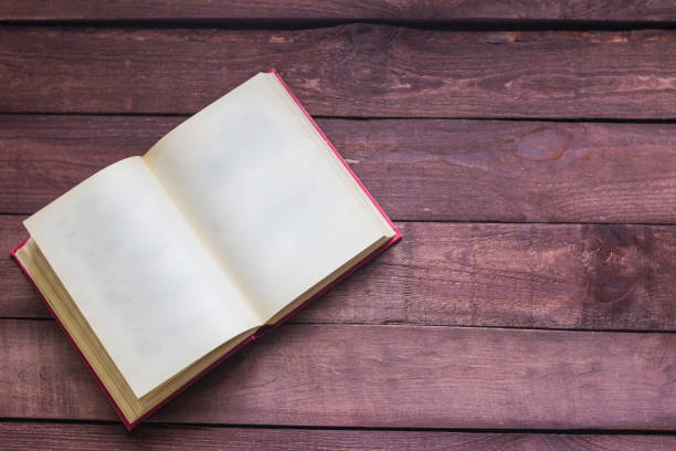 istock Open book is lying on the wooden table 645988282