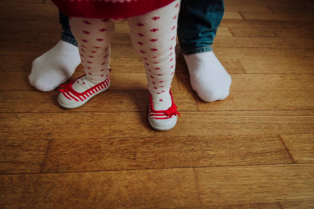 istock father helping little daughter to make first steps 645997956