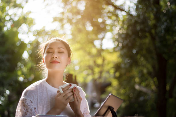 Beautiful women have enjoyed in the garden with coffee and tablet. stock photo