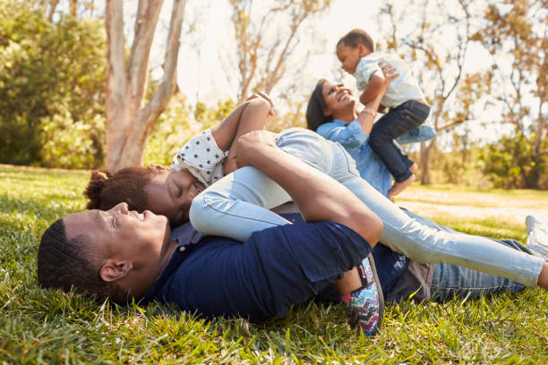 istock Parents Playing With Children On Grass In Summer Park 646011526