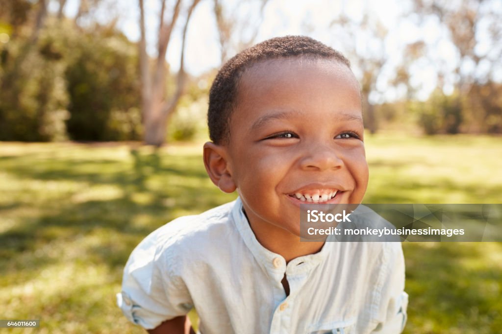 Outdoor Head And Shoulders Shot Of Young Boy In Park Child Stock Photo