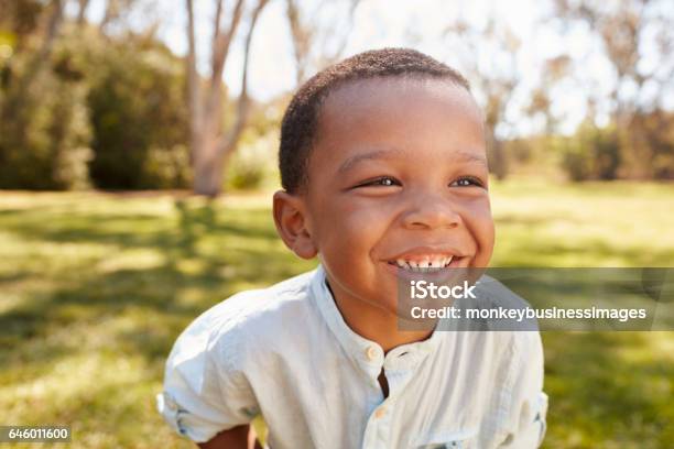 Outdoor Head And Shoulders Shot Of Young Boy In Park Stock Photo - Download Image Now