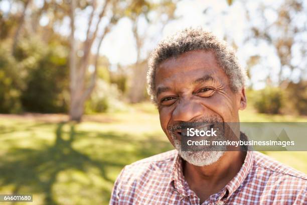 Outdoor Head And Shoulders Portrait Of Mature Man In Park Stock Photo - Download Image Now