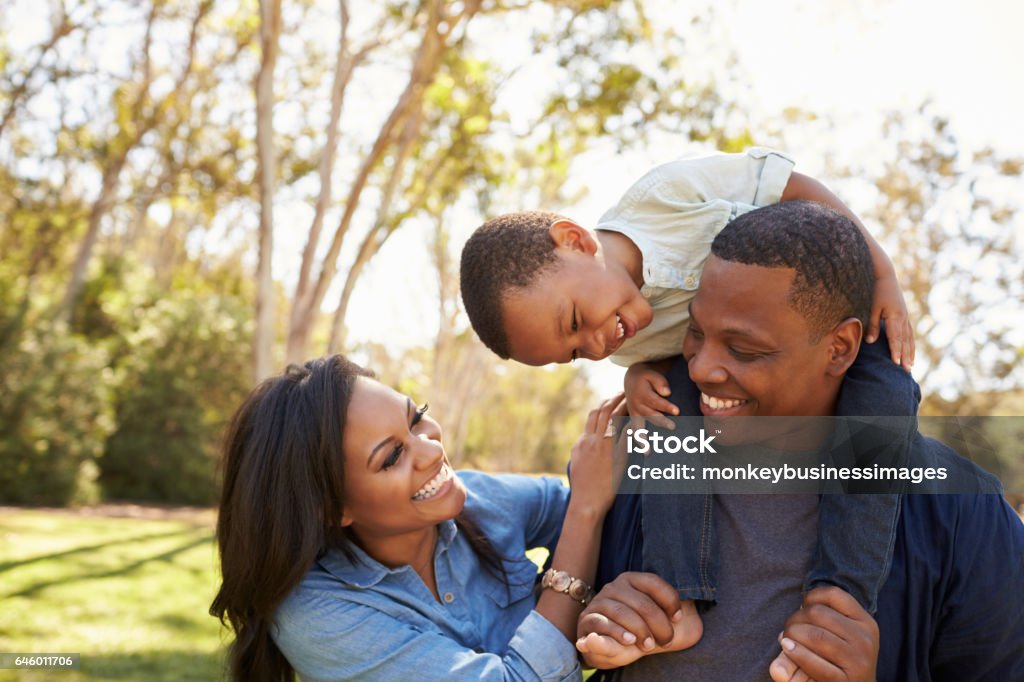 Eltern, Sohn auf den Schultern tragen, wie sie im Park Fuß - Lizenzfrei Familie Stock-Foto