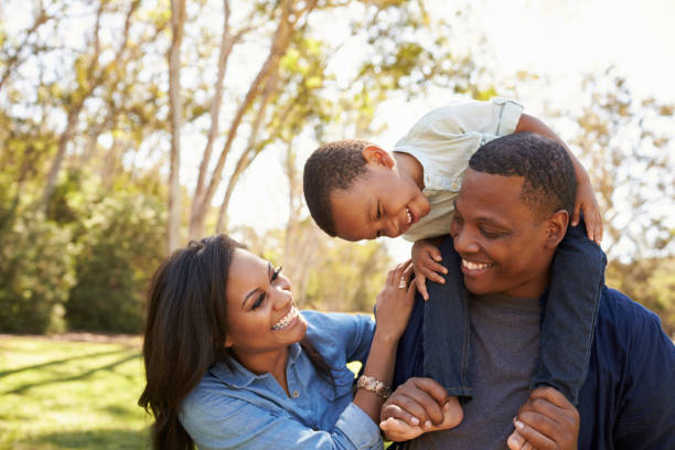 彼らは公園で散歩、肩の上の息子を運ぶ親 - three person family ストックフォトと画像