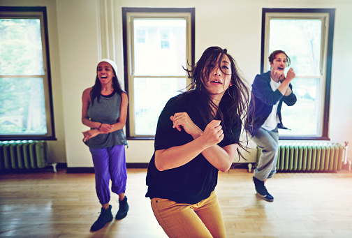 Shot of a group of young people dancing together in a studio