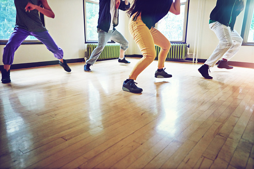 Cropped shot of a group of people dancing together in a studio